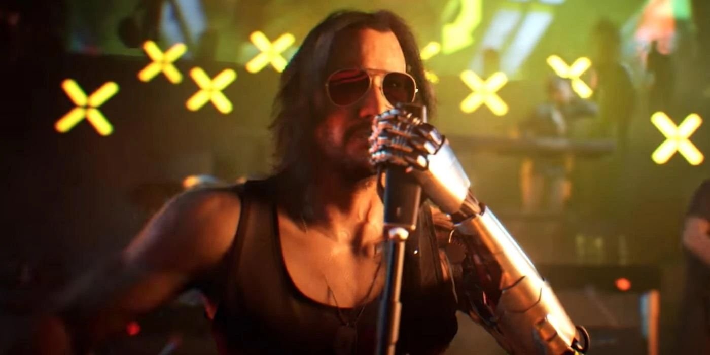Johnny Silverhand on stage, holding a microphone with his bionic arm, in Cyberpunk 2077.