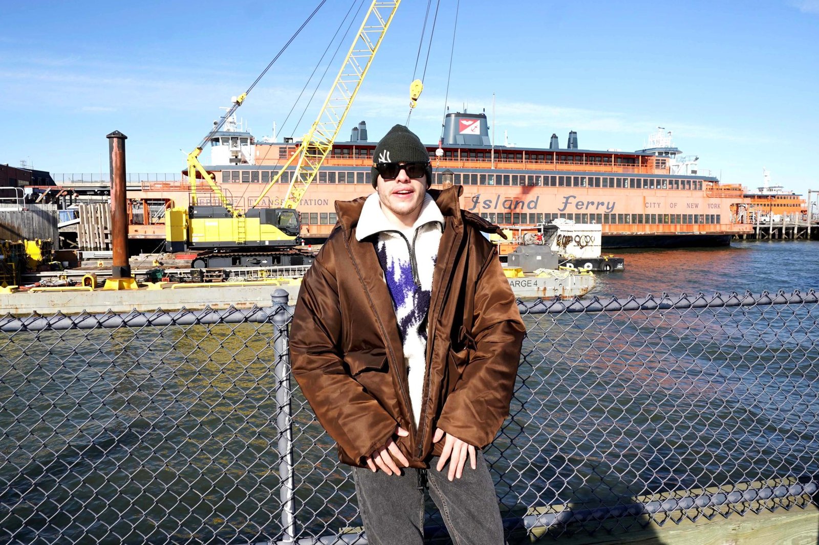 Pete Davidson standing in front of the ferry he bought. 