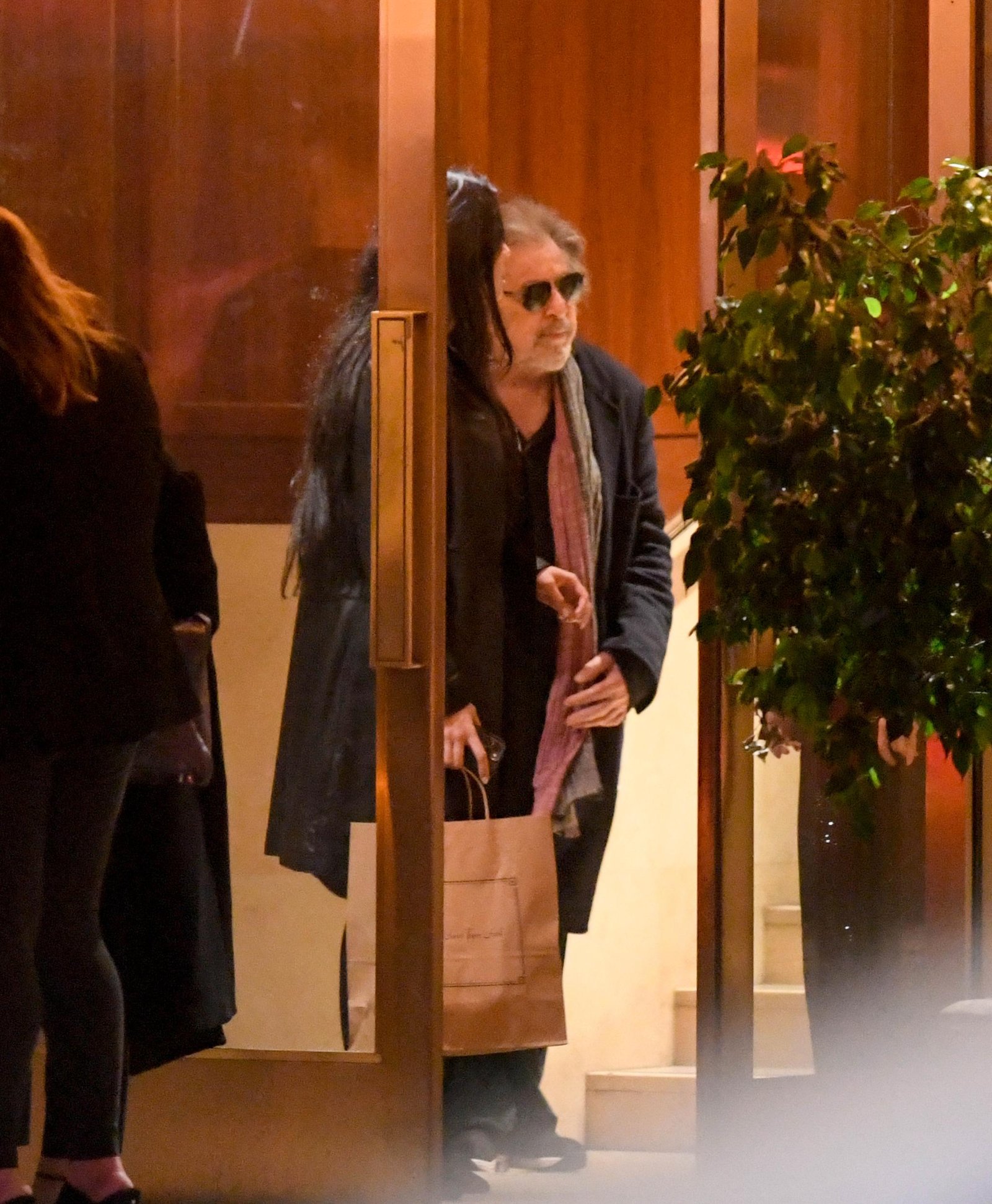 Al Pacino and Noor Alfallah in a hotel lobby. 