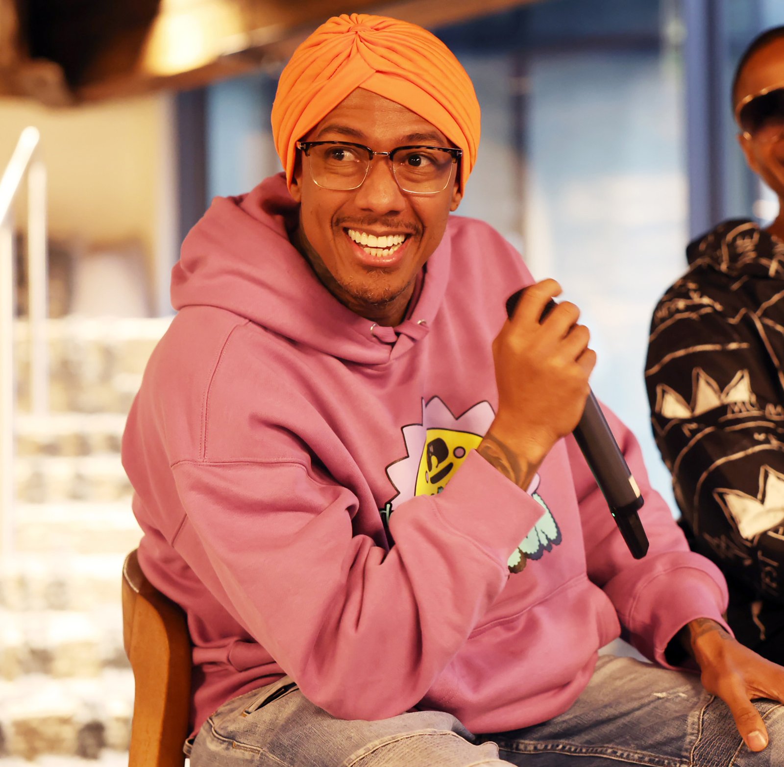 Nick Cannon in pink hoodie and yellow turban.